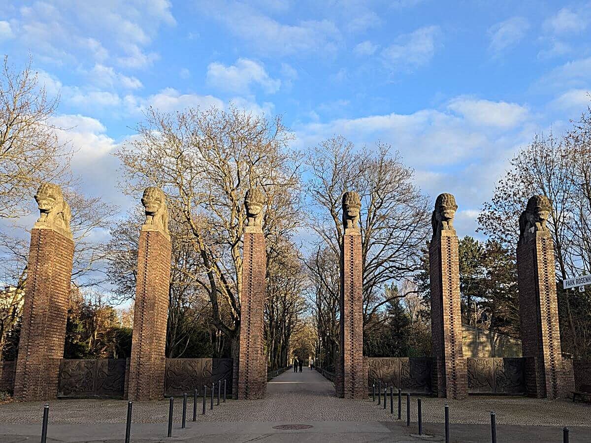 Löwentor mit massiven Klinkerpfeilern, kunstvoll gestalteten Bronze-Torflügeln und Löwenfiguren in der Rosenhöhe Darmstadt.